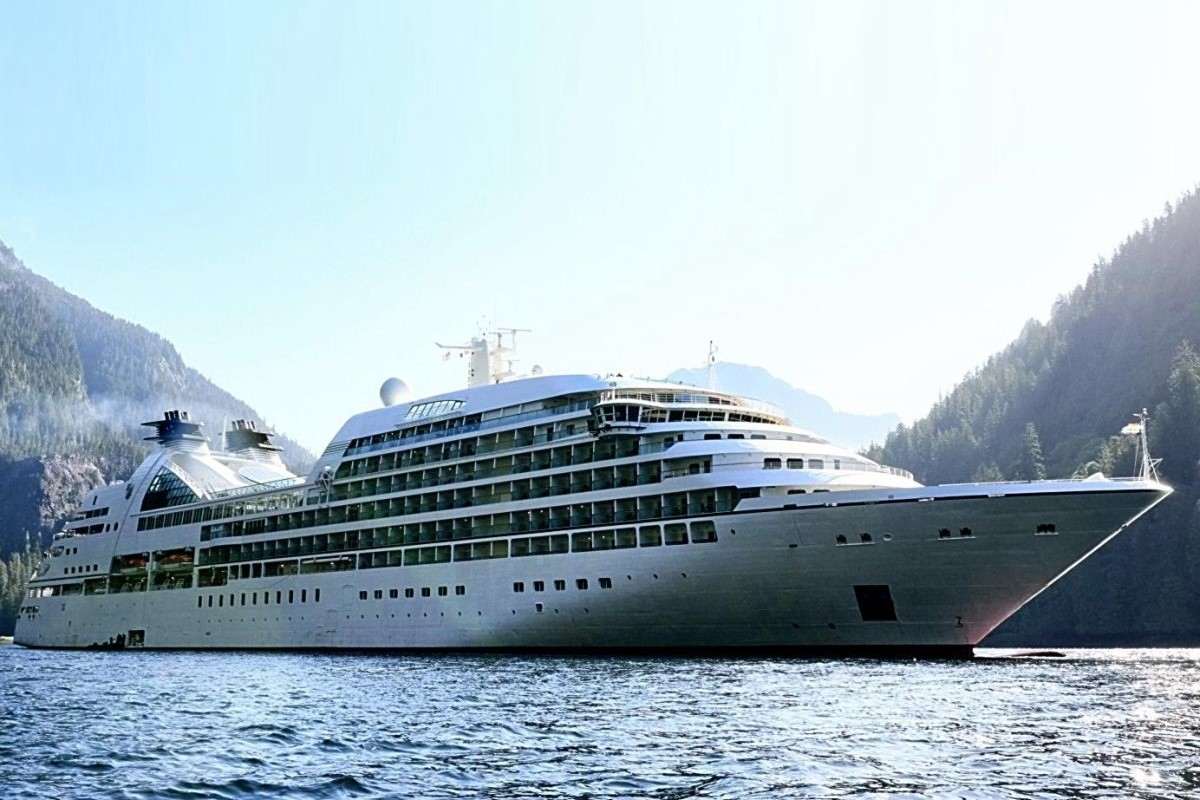 The Mitsui Ocean Fuji cruise ship sailing beside forested mountains