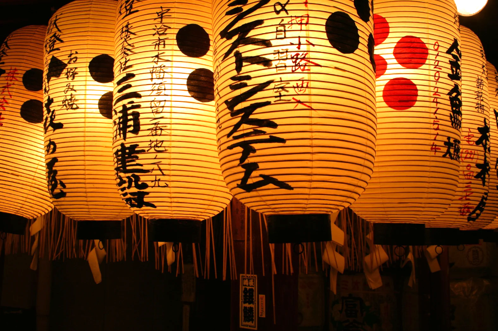 Glowing Japanese festival lanterns decorated with calligraphy